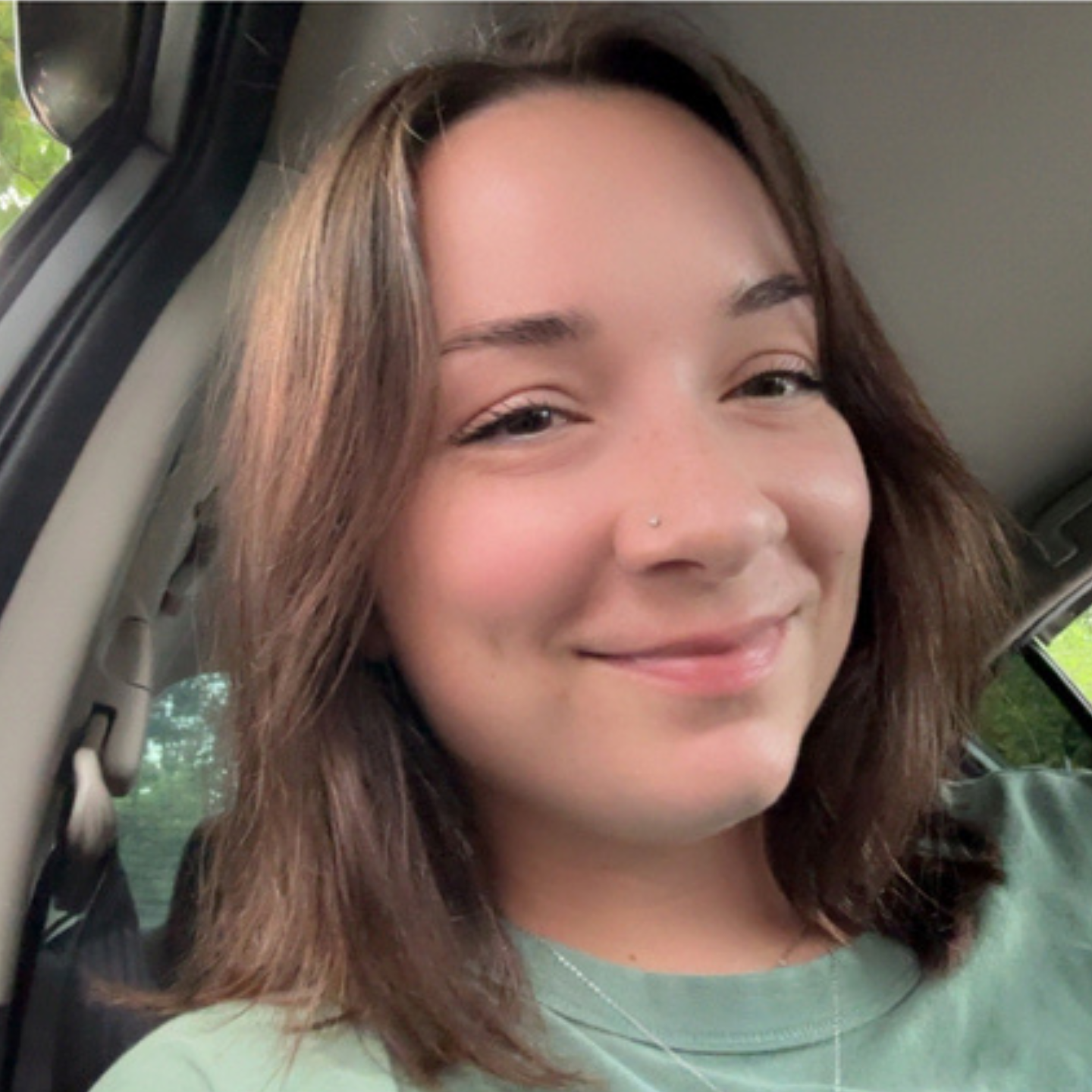 Fallon, a Greenville Technical College Radiologic Technology student, smiles for a selfie while sitting in a car.
