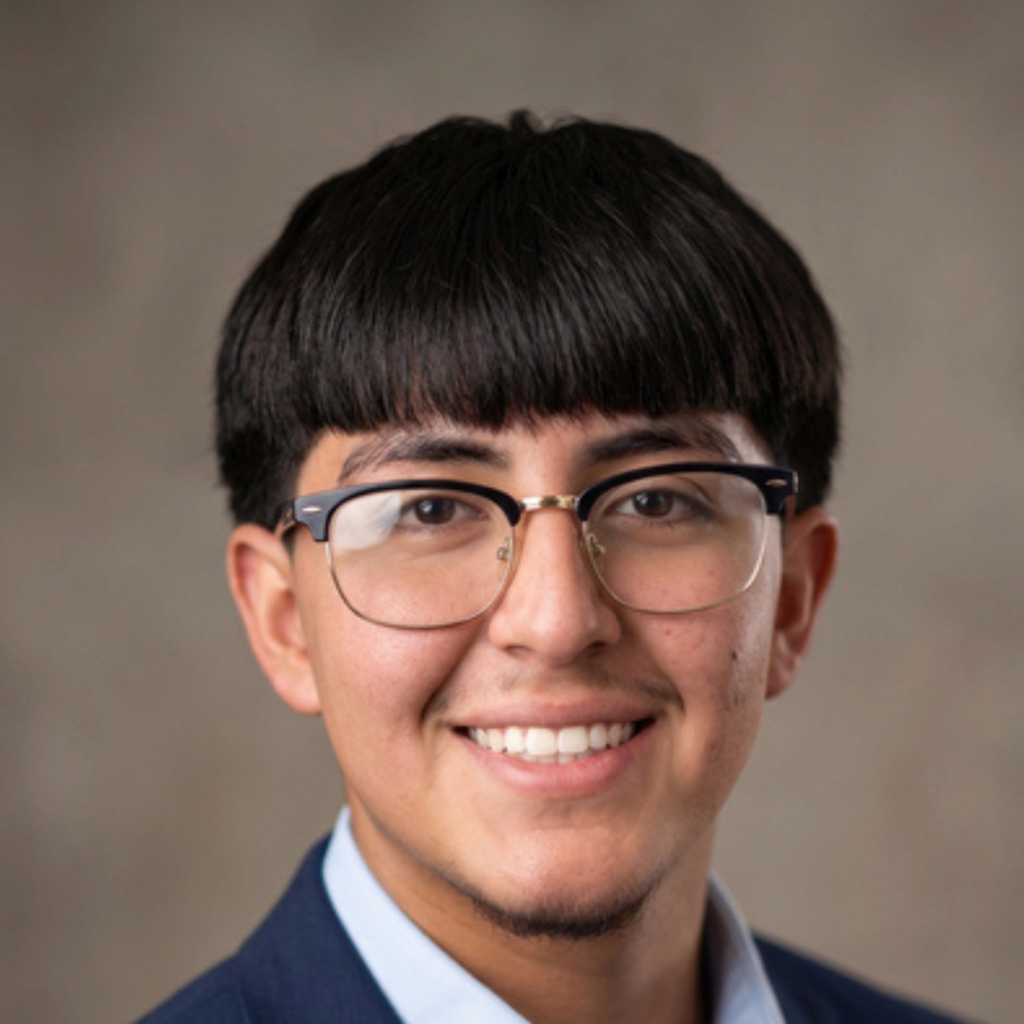 Professional headshot of Greenville Technical College student Rogelio, smiling and wearing glasses and a navy blazer.
